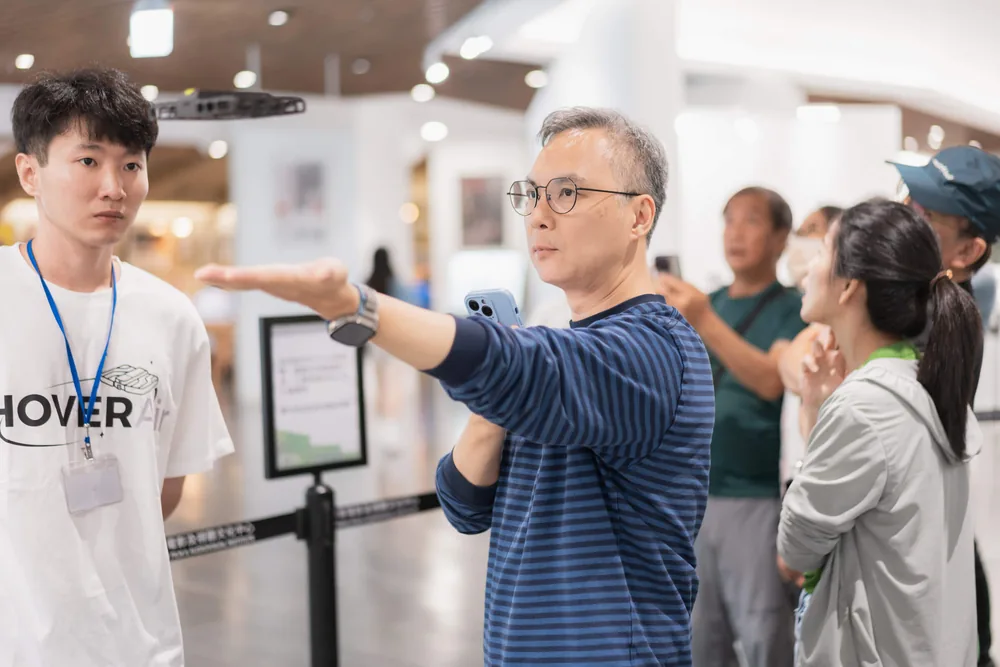 Staff walking customers through HOVERAir products in a Tokyo store
